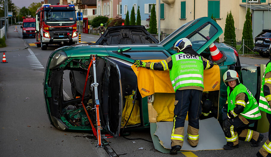 Feuerwehrmann deckt Schnittkante am verunfallten Fahrzeug ab